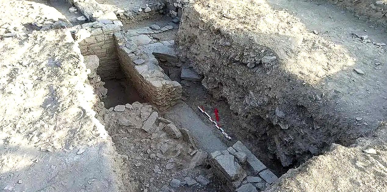 Αρχαιολογική τομή στο εργαστήριο γλυπτικής της Φλόγας Πάρου, με εμφανή θεμέλια τοίχων, λίθινες κατασκευές και εργαλεία ανασκαφής.