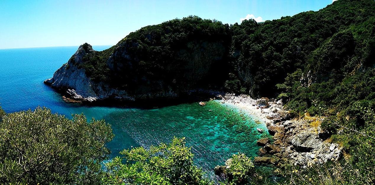 Πανοραμική θέα του κολπίσκου της Φακίστρας στο Πήλιο με καταπράσινα νερά, βραχώδεις ακτές και πυκνή βλάστηση.