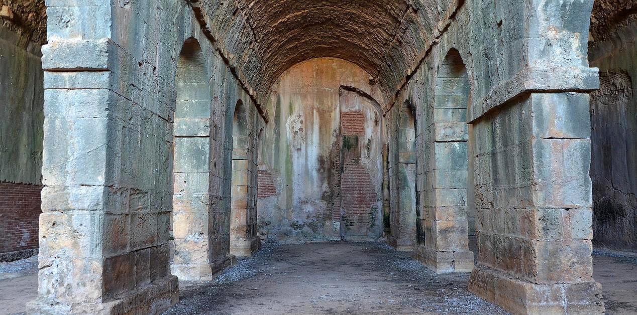 Εσωτερικό των ρωμαϊκών δεξαμενών της Άπτερας με πέτρινους πεσσούς και θολωτή οροφή, χαρακτηριστικό παράδειγμα ρωμαϊκής υδραυλικής τεχνολογίας στην Κρήτη.