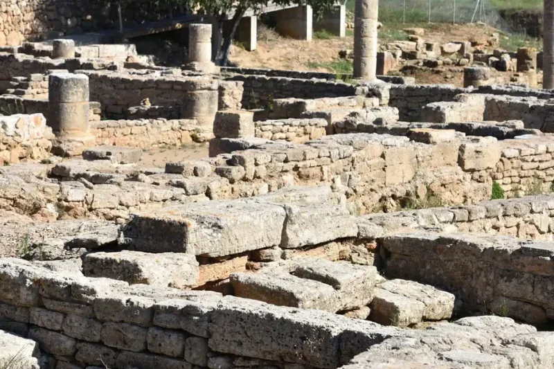 Ερείπια ρωμαϊκής κατασκευής στην αρχαία Pollentia της Μαγιόρκα, με εμφανείς πέτρινους τοίχους και κίονες, κάτω από τον ήλιο της Μεσογείου.