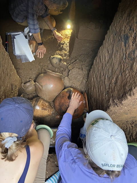 Αρχαιολόγοι εξετάζουν άθικτα αγγεία μέσα σε στενό ετρουσκικό ταφικό θάλαμο, κατά τη διάρκεια ανασκαφής στην κεντρική Ιταλία.