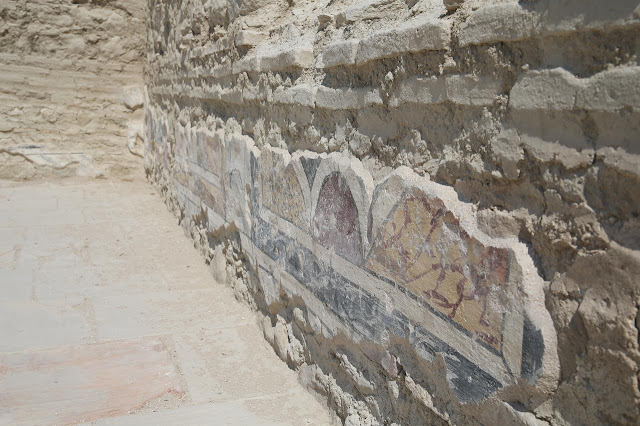 Λεπτομέρεια τοιχογραφιών στους εσωτερικούς τοίχους της ρωμαϊκής έπαυλης, με χρώματα και γεωμετρικά μοτίβα να διασώζονται στις αρχαίες επιφάνειες.