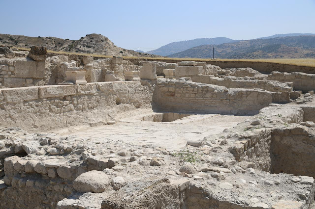 Κοντινή φωτογραφία των λίθινων τοίχων και των δαπέδων της ρωμαϊκής έπαυλης, με το φυσικό τοπίο της Μικράς Ασίας να διακρίνεται στο βάθος.