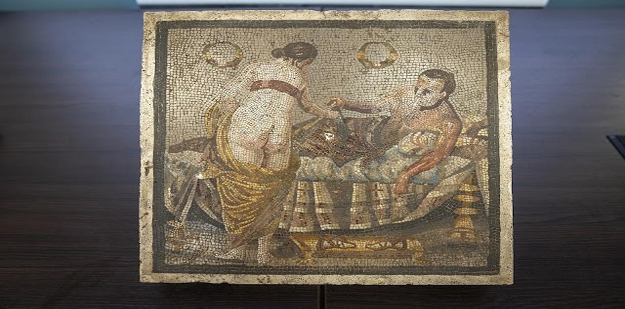 Ρωμαϊκό ψηφιδωτό ερωτικού περιεχομένου από την Πομπηία. Απεικονίζει ζευγάρι σε ερωτική σκηνή πάνω σε πολυτελές ανάκλιντρο με διακοσμητικά στοιχεία.