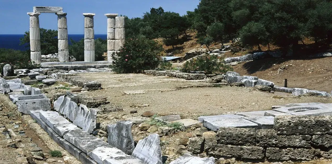 Αρχαία ερείπια και κίονες του Ιερού των Μεγάλων Θεών στη Σαμοθράκη, με θέα προς τη θάλασσα και το φυσικό τοπίο.