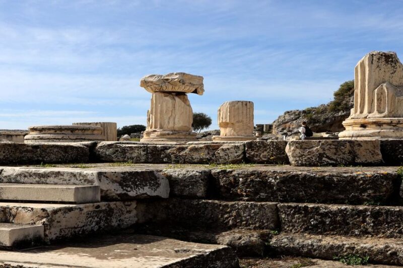 Ερείπια αρχαίων κιόνων στον αρχαιολογικό χώρο της Ελευσίνας κάτω από καθαρό ουρανό