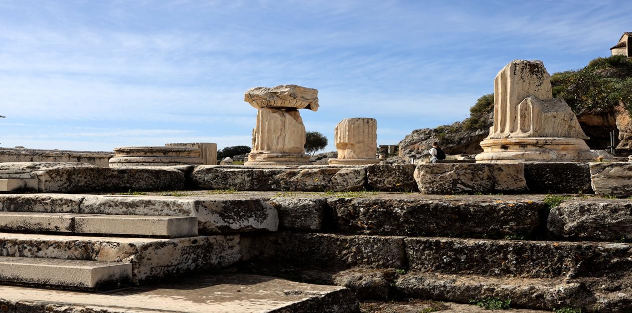 Ερείπια αρχαίων κιόνων στον αρχαιολογικό χώρο της Ελευσίνας κάτω από καθαρό ουρανό
