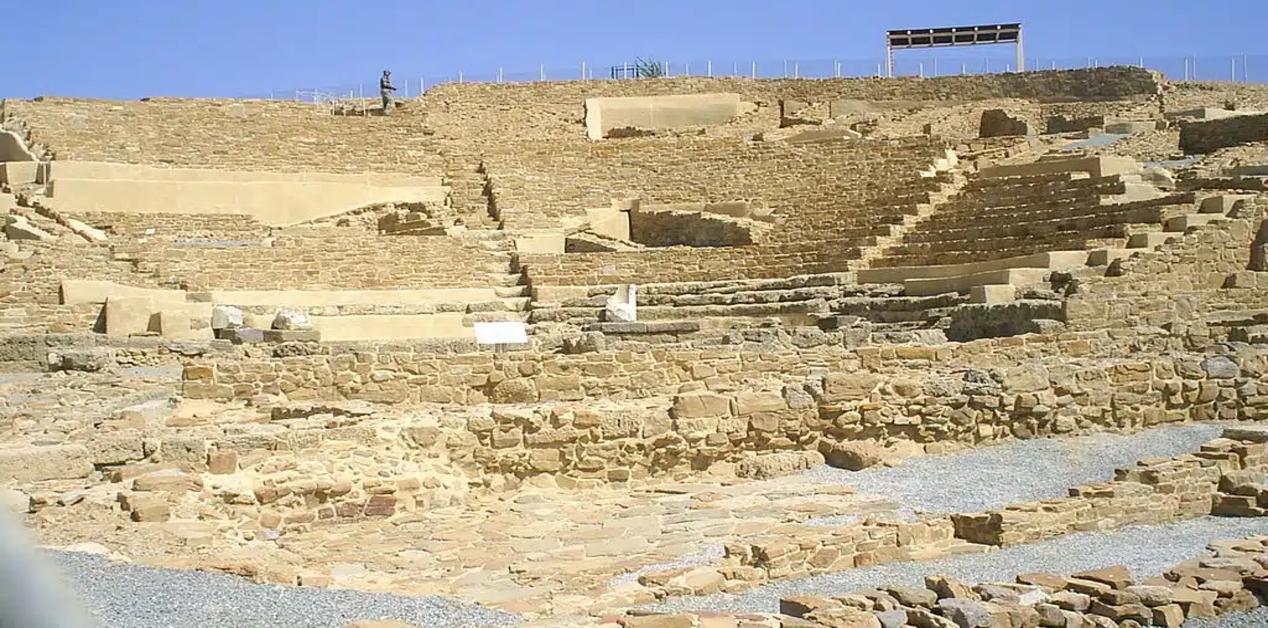 Ηφαιστία Λήμνου: Η Αρχαία Πόλη του Θεού Ηφαίστου - Άποψη των πέτρινων ερειπίων και των αναστηλωμένων κερκίδων του αρχαίου θεάτρου της Ηφαιστίας στη Λήμνο, κάτω από έναν καθαρό γαλάζιο ουρανό.