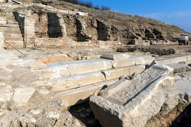 Αρχαιολογικά ερείπια του ρωμαϊκού φόρουμ στην Ηράκλεια Σιντική με ορατά μαρμάρινα τμήματα και τοιχοποιία.