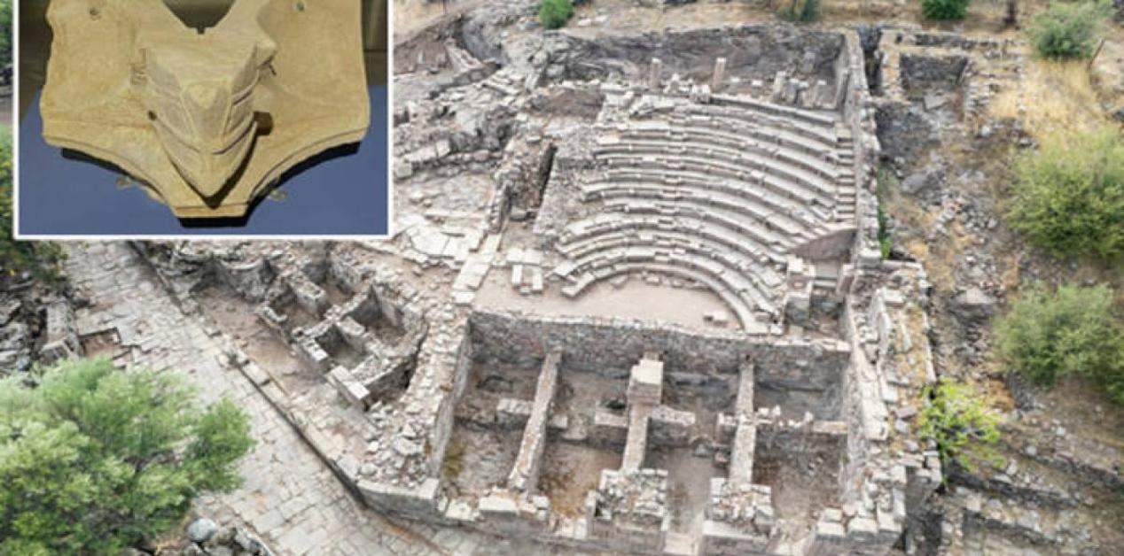 Αρχαίο ηλιακό ρολόι 2.200 ετών σε σχήμα πλώρης πλοίου που βρέθηκε στην Αιγαία, με φόντο το Βουλευτήριο της πόλης.