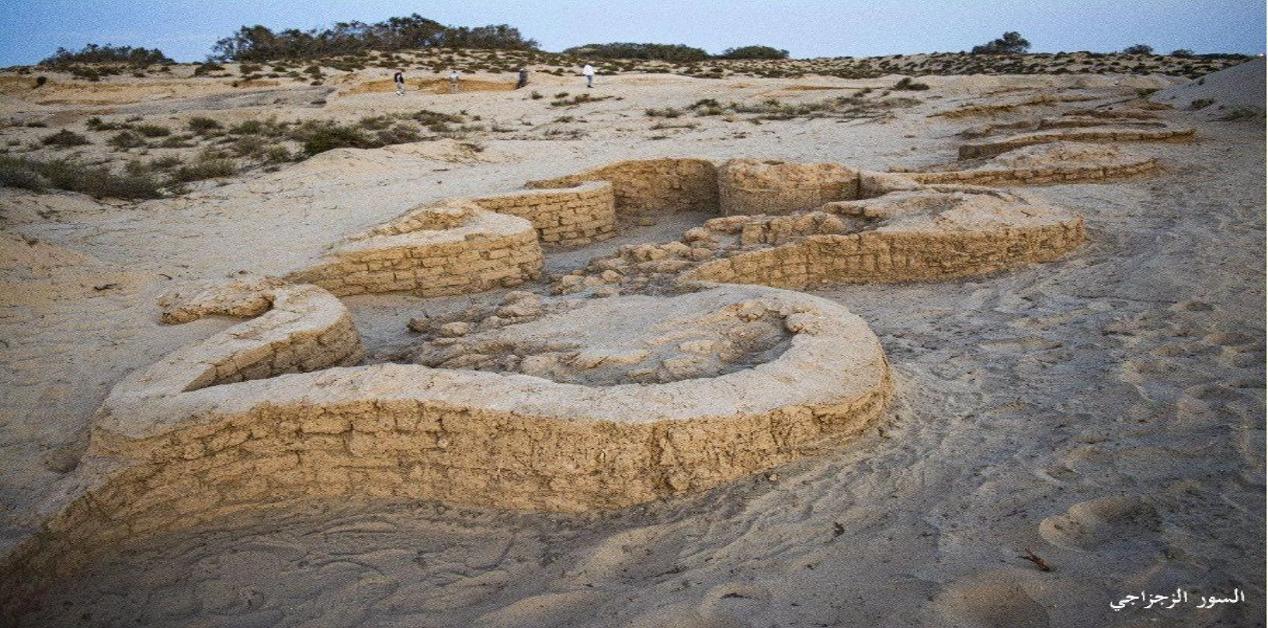 Ερείπια αρχαίου αιγυπτιακού φρουρίου από πλίνθους στο Σινά, ανασκαμμένα σε αμμώδες τοπίο με θαμνώδη βλάστηση.