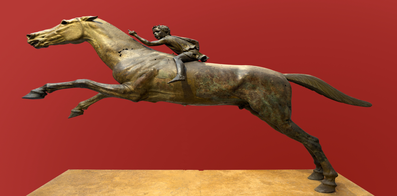 Ιππέας του Αρτεμισίου: Χάλκινο άγαλμα που δείχνει έναν νεαρό ιππέα σε ένα καλπάζον άλογο, με κόκκινο φόντο. Το άλογο είναι σε πλήρη κίνηση, με τα μπροστινά πόδια σηκωμένα, ενώ ο αναβάτης κοιτάζει πίσω και εκτείνει το δεξί χέρι.
