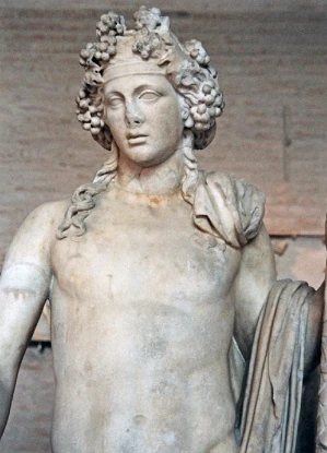 Μαρμάρινη προτομή του Διονύσου. Ο θεός έχει πλούσια, κατσαρά μαλλιά, στεφανωμένα με σταφύλια. Τα μάτια του είναι στραμμένα ελαφρώς προς τα κάτω. Φοράει χιτώνα.