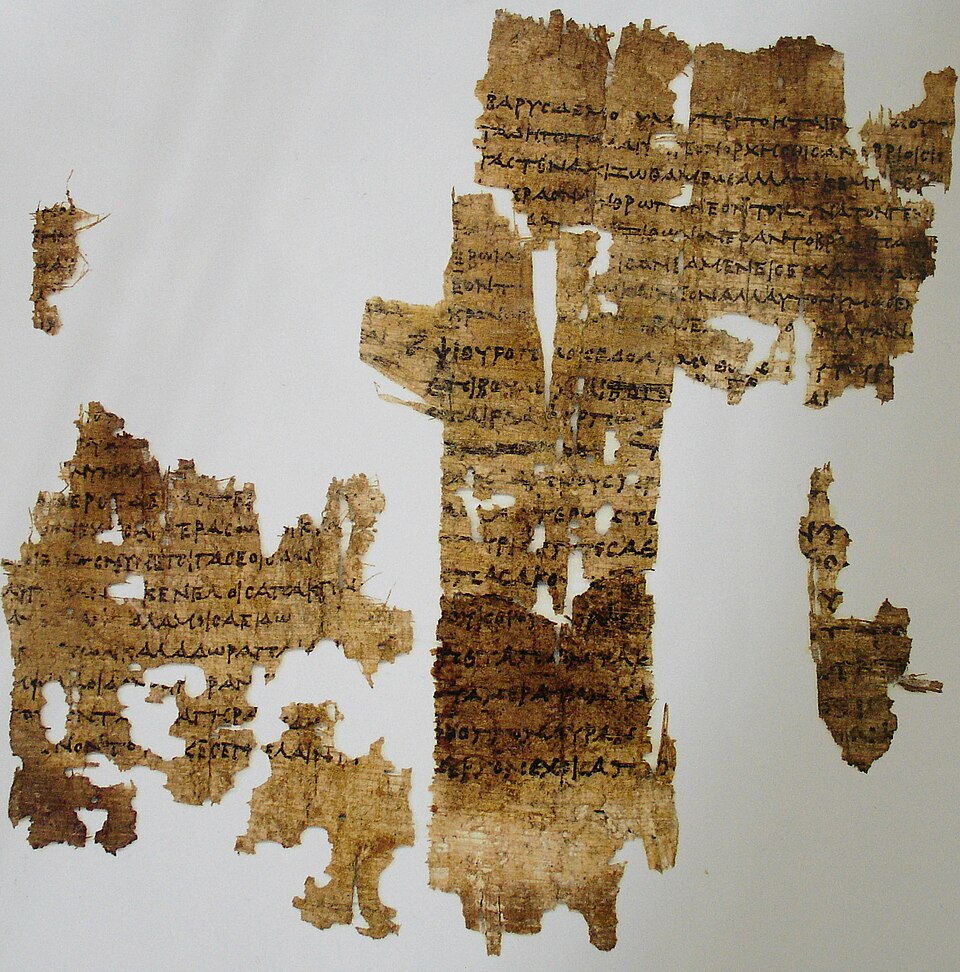 Ασύμμετρα, εξαιρετικά φθαρμένα κομμάτια παπύρου με μεγάλες οπές, συναρμολογημένα σε λευκό φόντο.