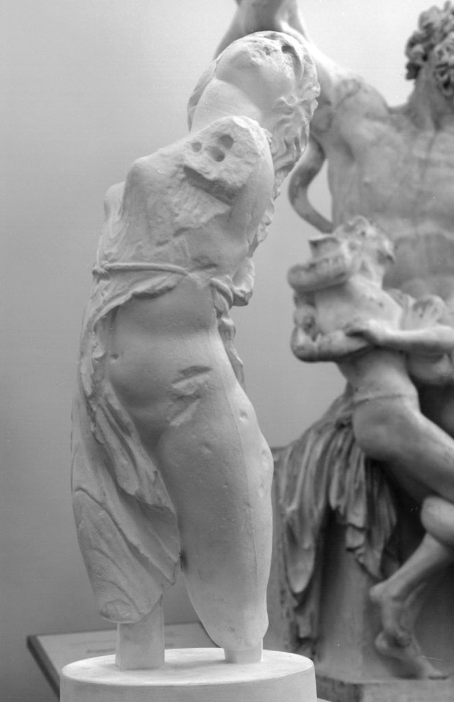 Λεπτομέρεια αρχαίου μαρμάρινου γλυπτού που απεικονίζει γυναικεία μορφή με λεπτό χιτώνα που αναδεικνύει την κίνηση.