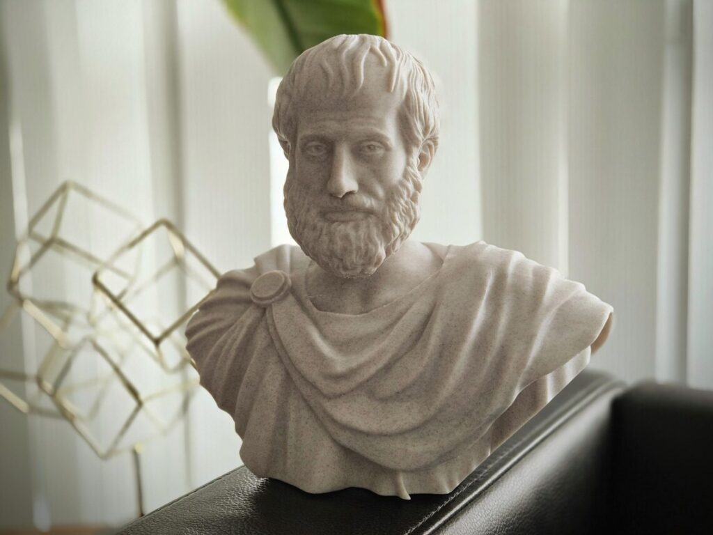 Μαρμάρινη προτομή του αρχαίου Έλληνα φιλοσόφου Αριστοτέλη τοποθετημένη σε φωτεινό εσωτερικό χώρο.