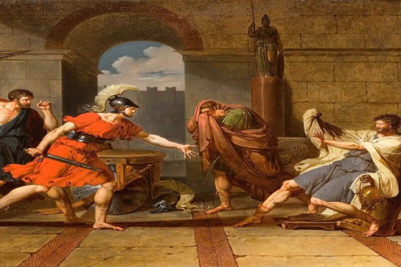 Τιμολέων, ο αρχαίος Έλληνας στρατηγός που έσωσε τον αδελφό του μόνο και μόνο για να τον σκοτώσει αργότερα - Ένας νεοκλασικός πίνακας που απεικονίζει τέσσερις άνδρες σε ένα αρχαιοπρεπές πέτρινο δωμάτιο. Αριστερά, ένας μυώδης άνδρας με μπλε χιτώνα σηκώνει ένα σπαθί. Στο κέντρο, ένας άνδρας με κόκκινο χιτώνα και κράνος σπεύδει να τον σταματήσει, με το χέρι απλωμένο. Δεξιά, ένας άνδρας με γκρι χιτώνα κάθεται σε θρόνο, τρομαγμένος. Μεταξύ τους, ένας άνδρας με καφέ μανδύα κρύβει το πρόσωπό του. Στο βάθος, ένας βωμός και ένα άγαλμα.