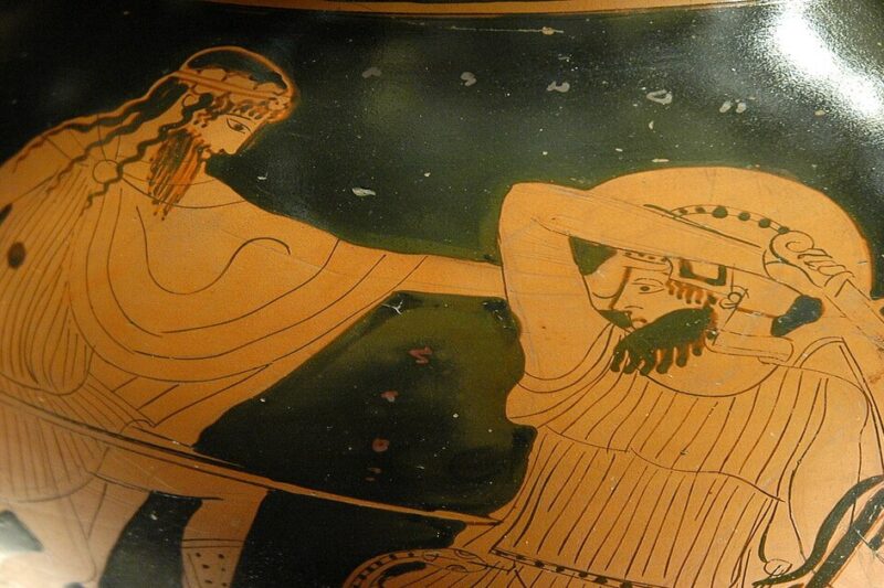 Κοντινό πλάνο ερυθρόμορφης αγγειογραφίας. Απεικονίζει μια μονομαχία μεταξύ ενός Έλληνα πολεμιστή και ενός Γίγαντα. Ο Έλληνας (ίσως ο Ηρακλής) επιτίθεται με δόρυ, ενώ ο Γίγαντας προσπαθεί να αμυνθεί.