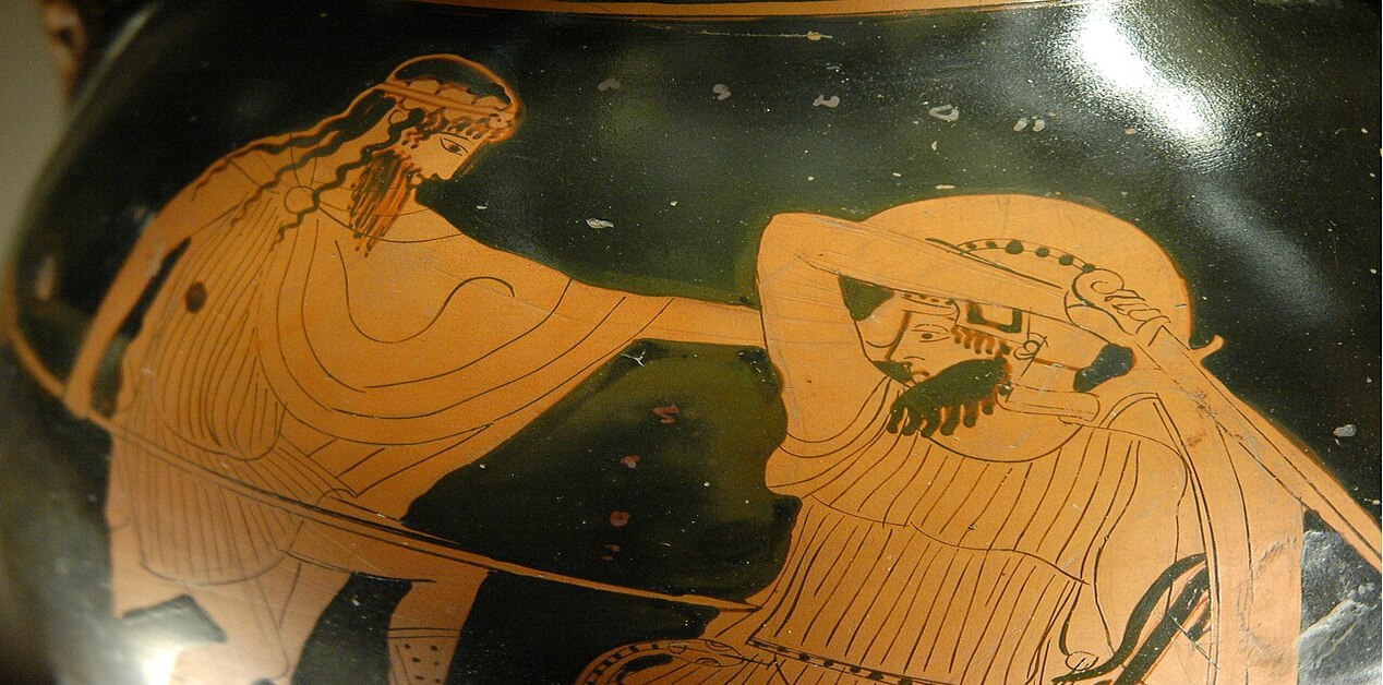Κοντινό πλάνο ερυθρόμορφης αγγειογραφίας. Απεικονίζει μια μονομαχία μεταξύ ενός Έλληνα πολεμιστή και ενός Γίγαντα. Ο Έλληνας (ίσως ο Ηρακλής) επιτίθεται με δόρυ, ενώ ο Γίγαντας προσπαθεί να αμυνθεί.