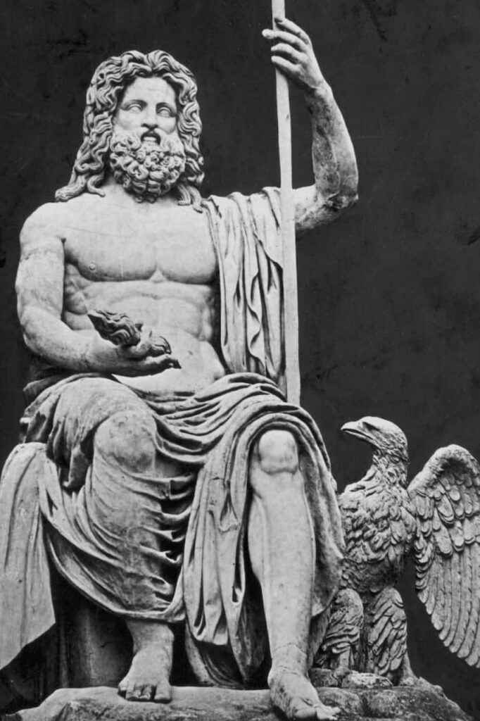 Μια ασπρόμαυρη φωτογραφία ενός καθήμενου μαρμάρινου αγάλματος του Δία, με τον αετό στο ένα χέρι και ένα σκήπτρο στο άλλο, και έναν αετό στη βάση.
